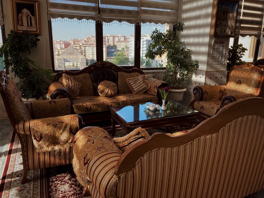 A beautifully decorated living room featuring vintage sofas and a coffee table set against a city skyline.